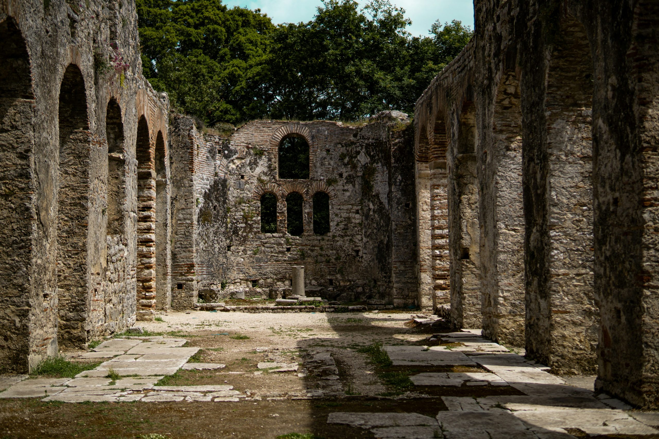 Stone ruins among trees at the archaeological site of Butrint.
