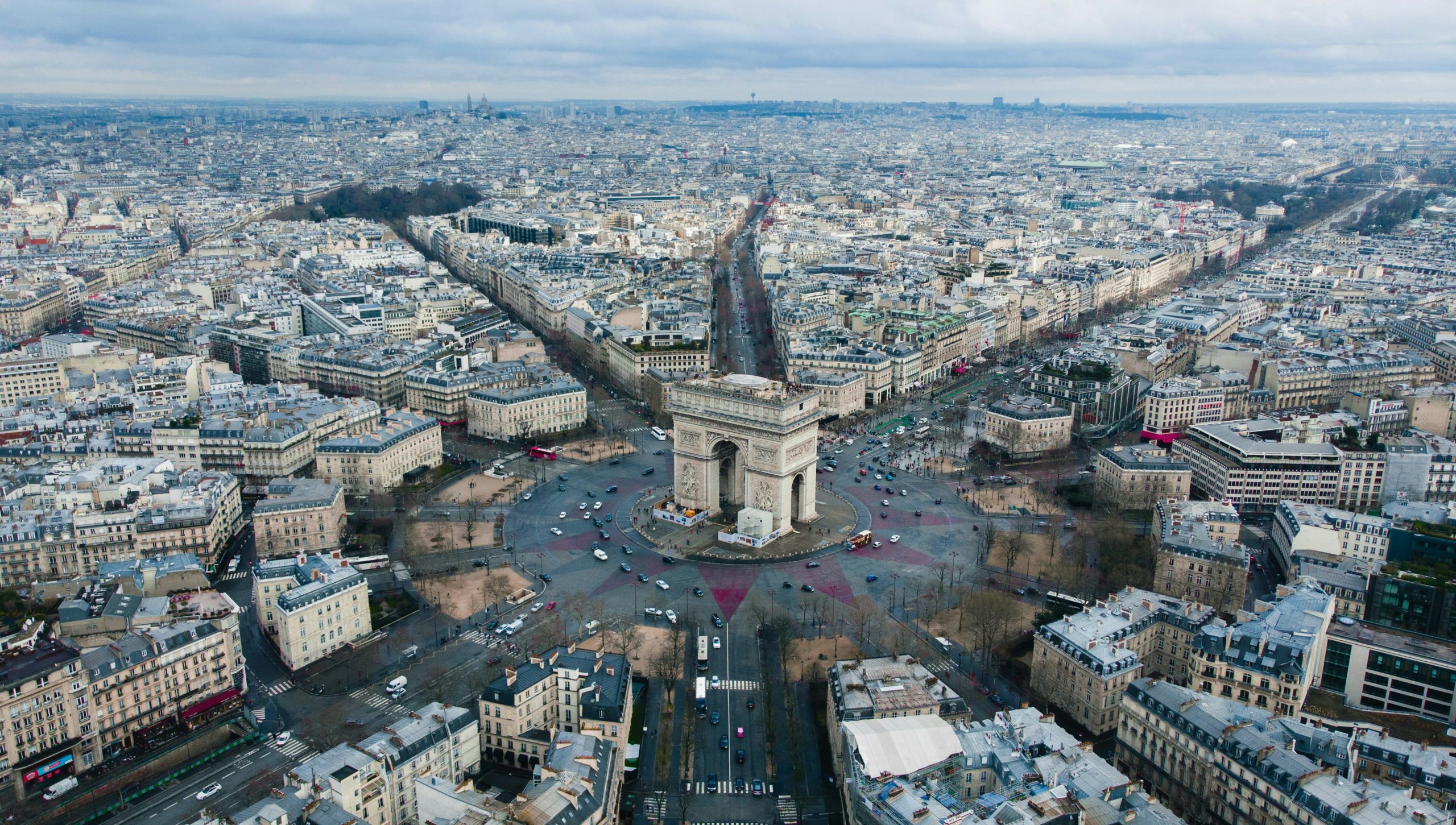 Aerial picture of Arc de Triomphe in France. Many buildings.