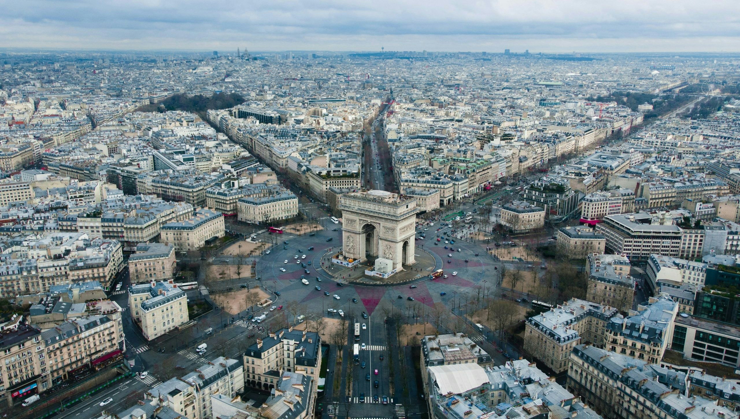Aerial picture of Arc de Triomphe in France. Many buildings.
