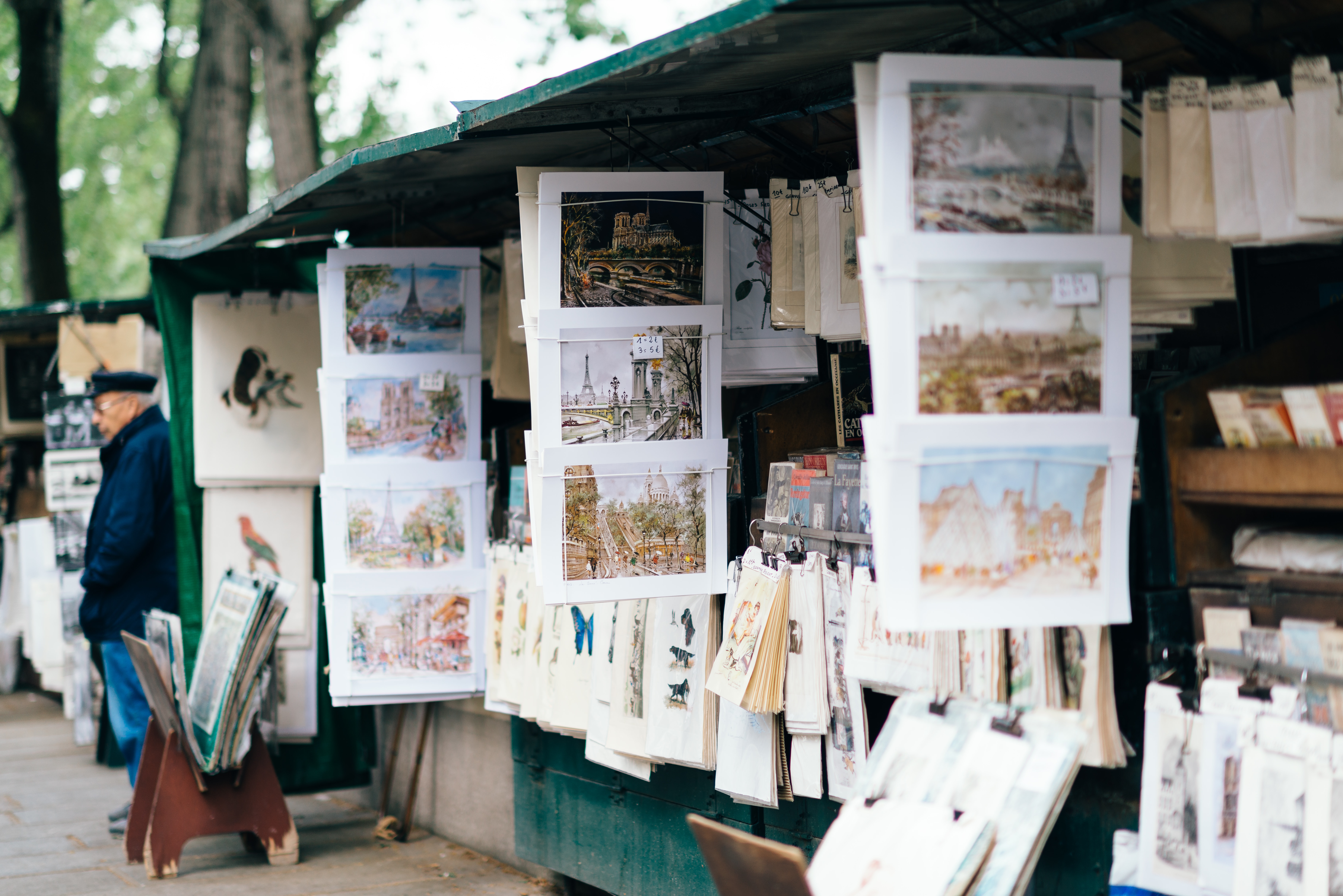 Postcards and prints hang along a Parisian riverside book stall in France