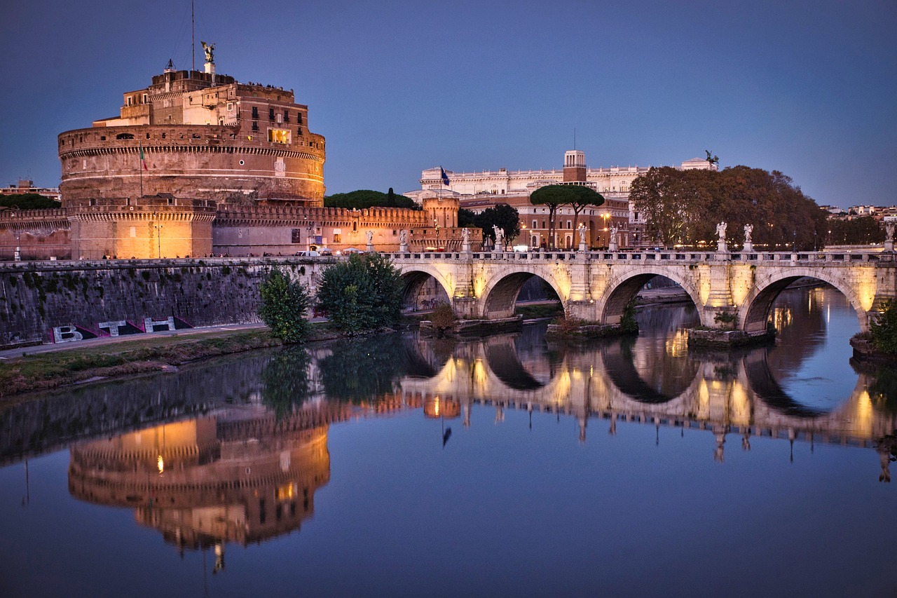 Castel Sant'Angelo and its bridge reflected in the Tiber at dusk