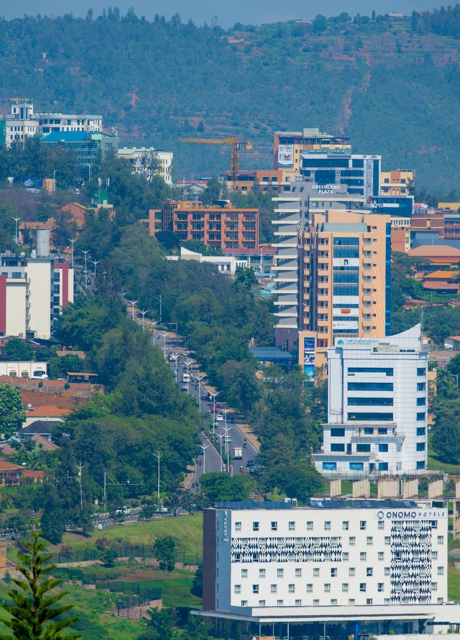 Aerial view of a hillside city skyline under a clear sky.