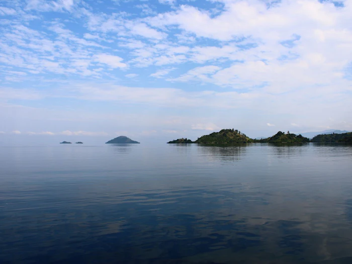 Small islands rising from the still water of a lake.