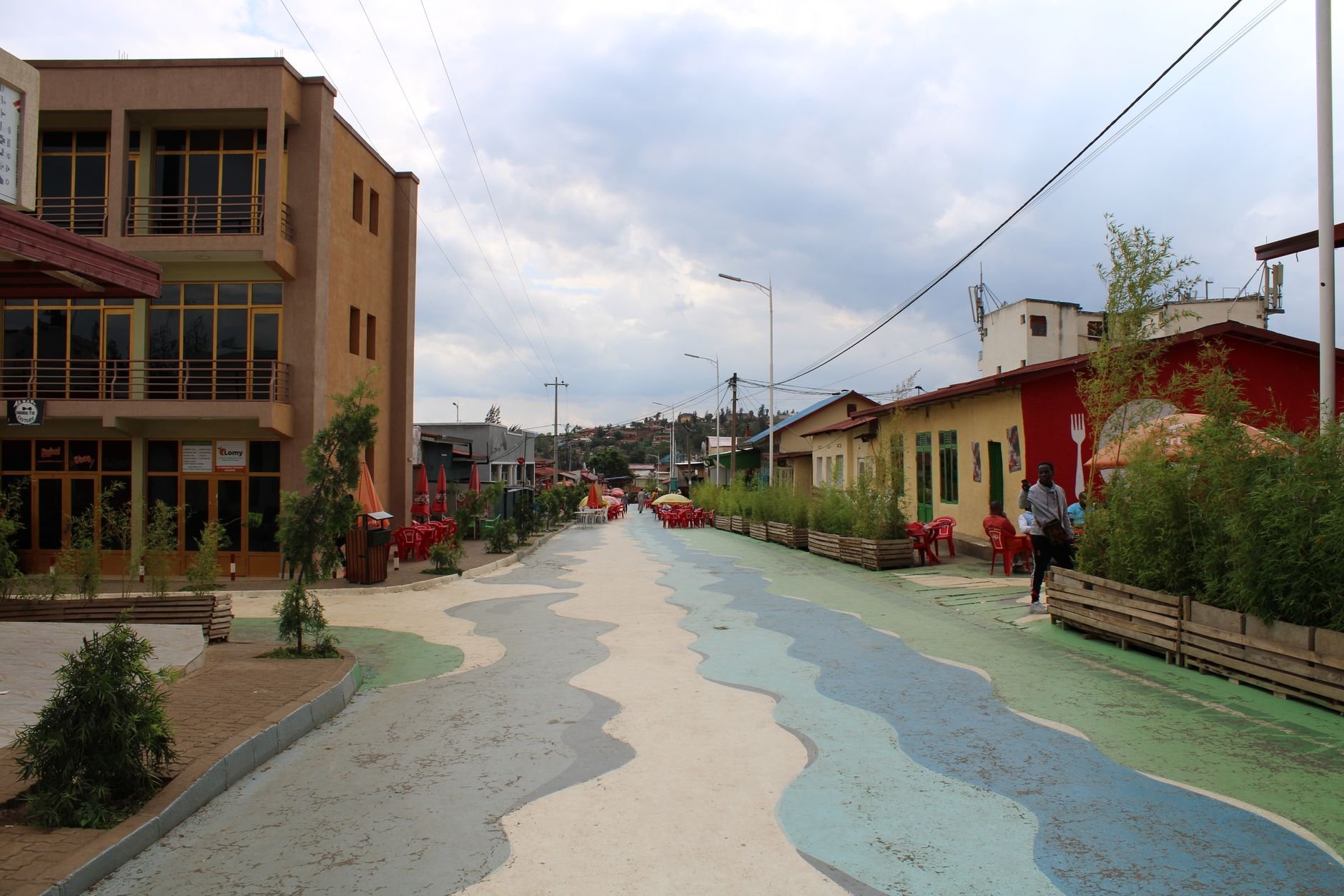 A colorful city street with painted shopfronts and pedestrians.