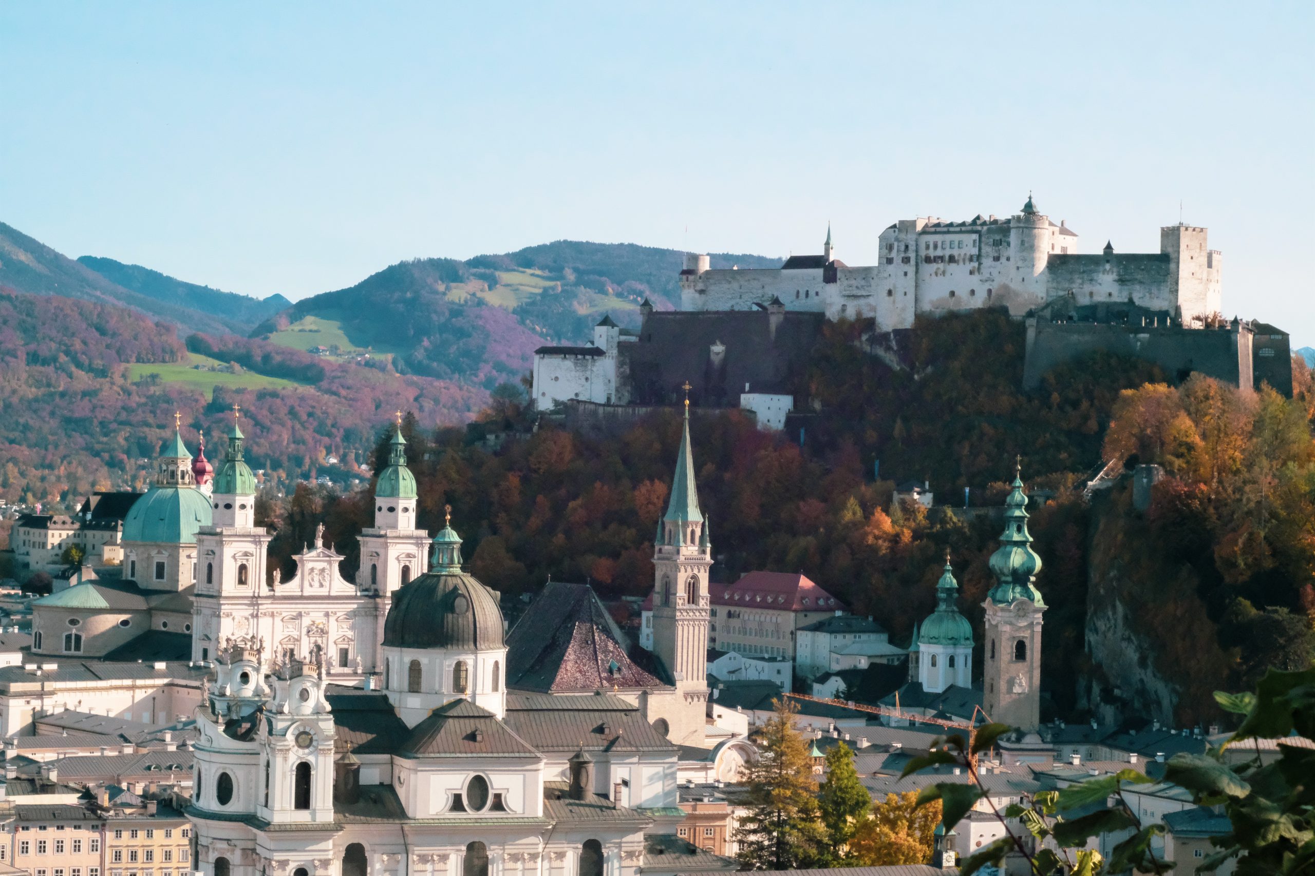 Students take in a hilltop fortress overlooking Salzburg's domed churches and autumn hillsides