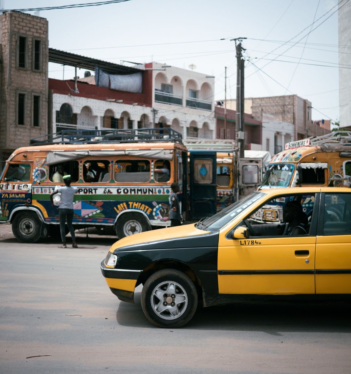 A yellow taxi and a bus on a city street.
