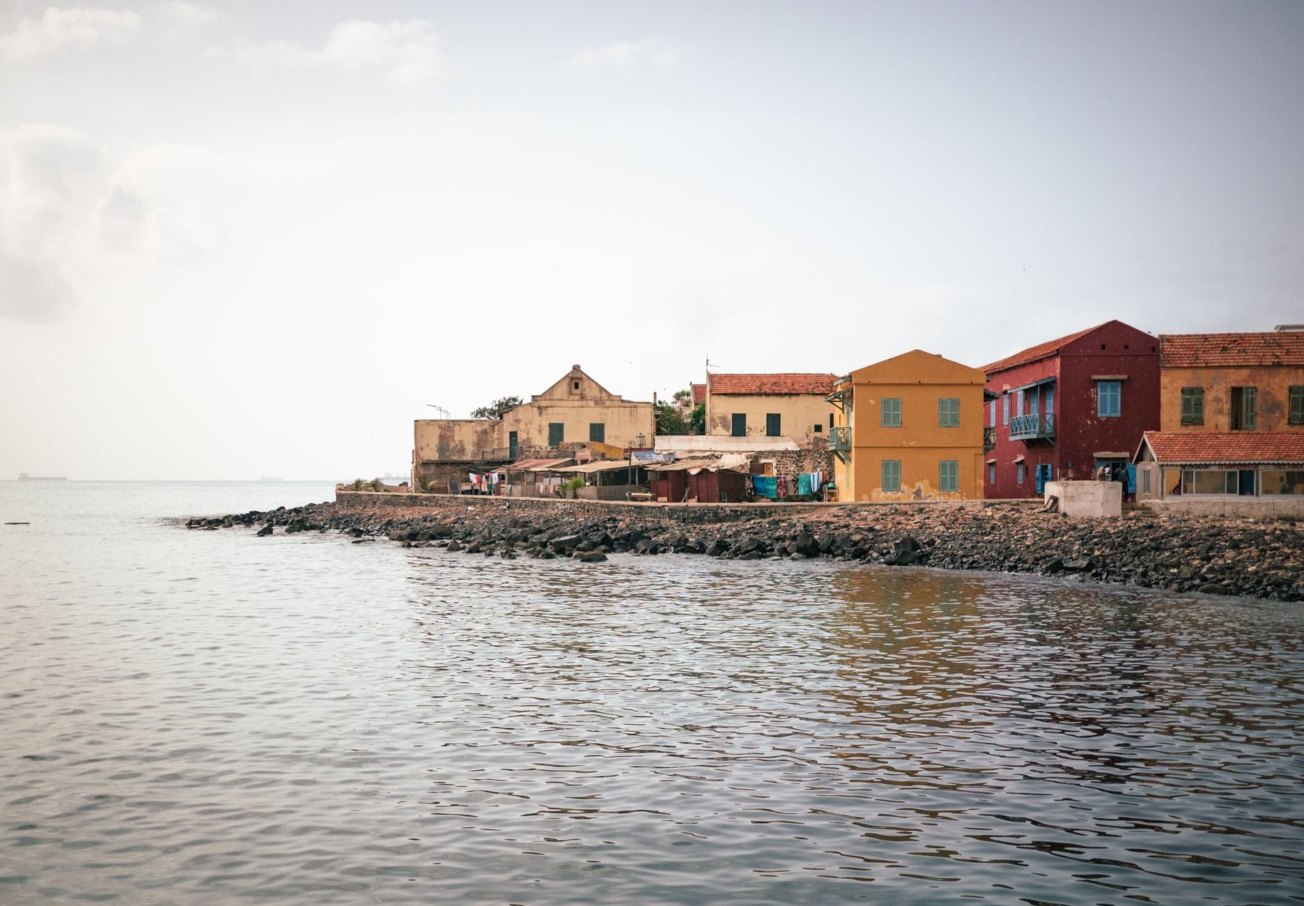 Low coastal buildings facing calm water.