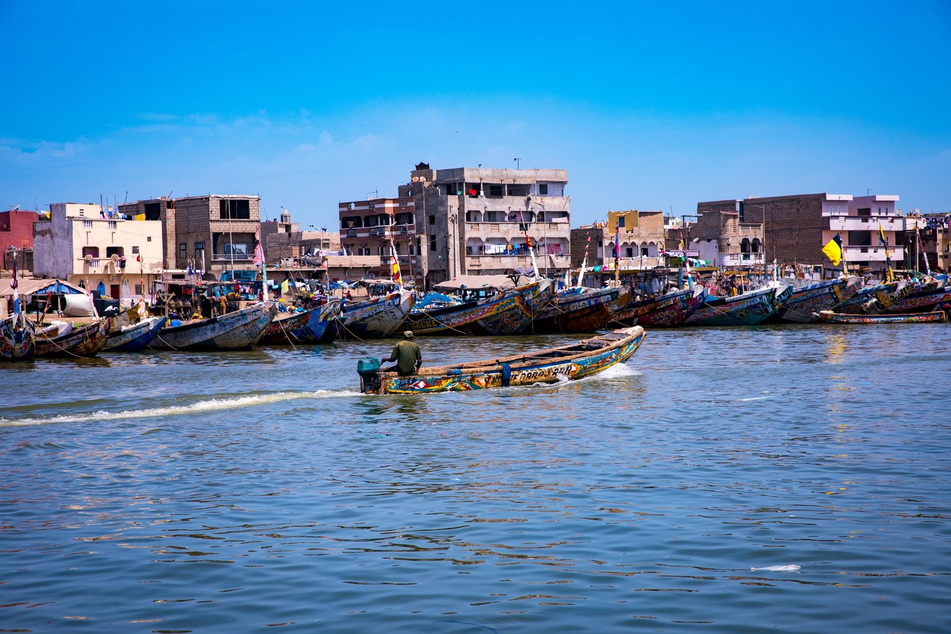Colorful fishing boats along a coastal village shoreline.