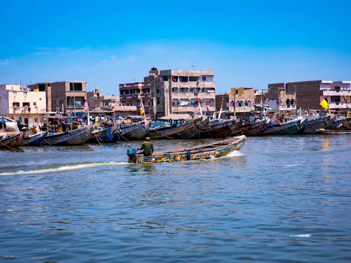 Colorful fishing boats along a coastal village shoreline.