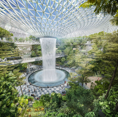 The Rain Vortex waterfall cascades through Jewel Changi's glass dome surrounded by lush indoor gardens