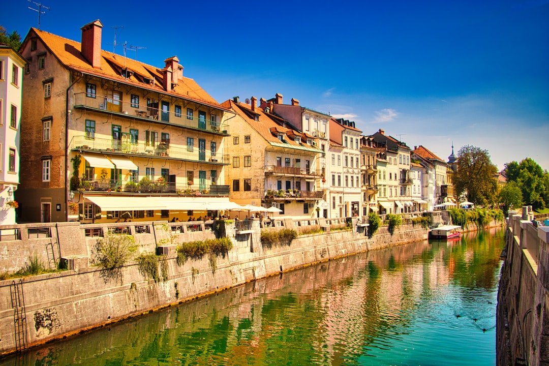A river lined with pale stone buildings under a bridge in a historic city center.