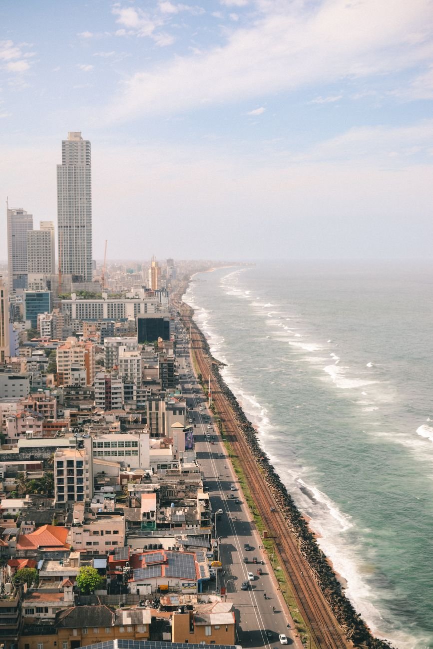 A panoramic coastal skyline of high-rise buildings along the water.