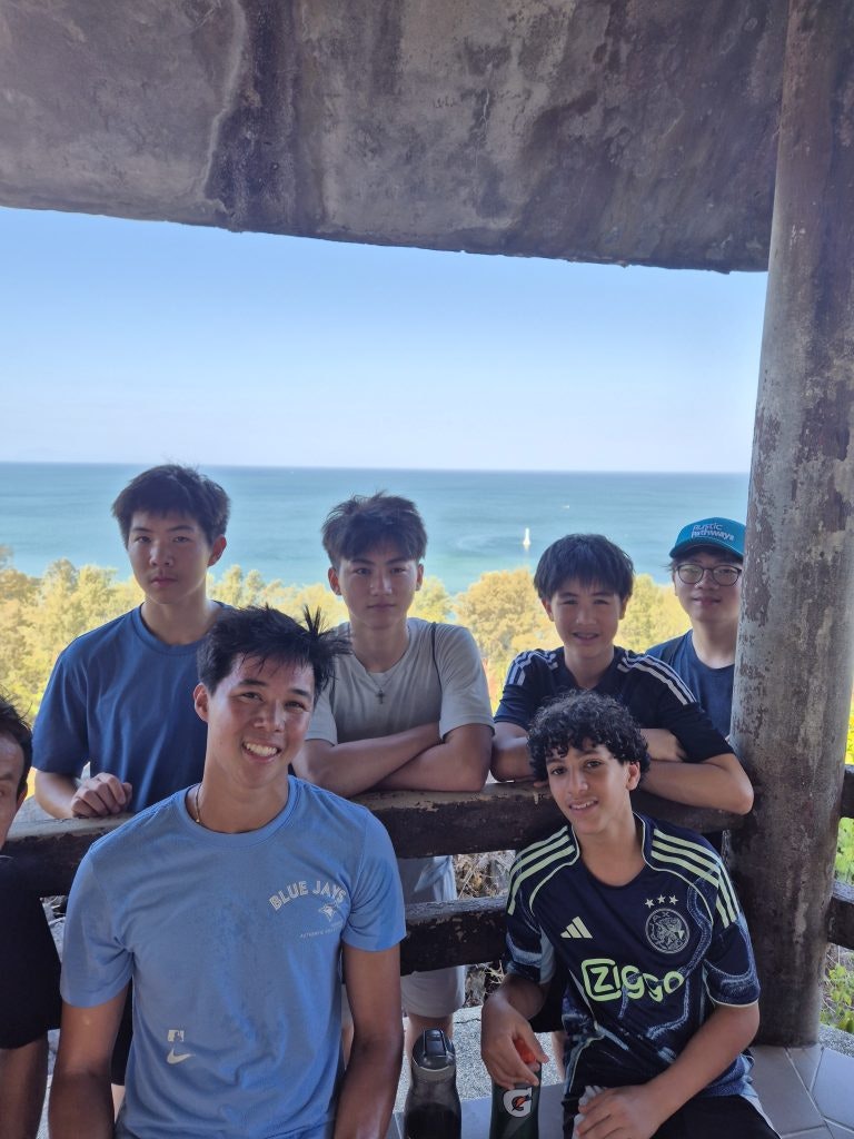 Students of different grades resting together during a hike in Thailand