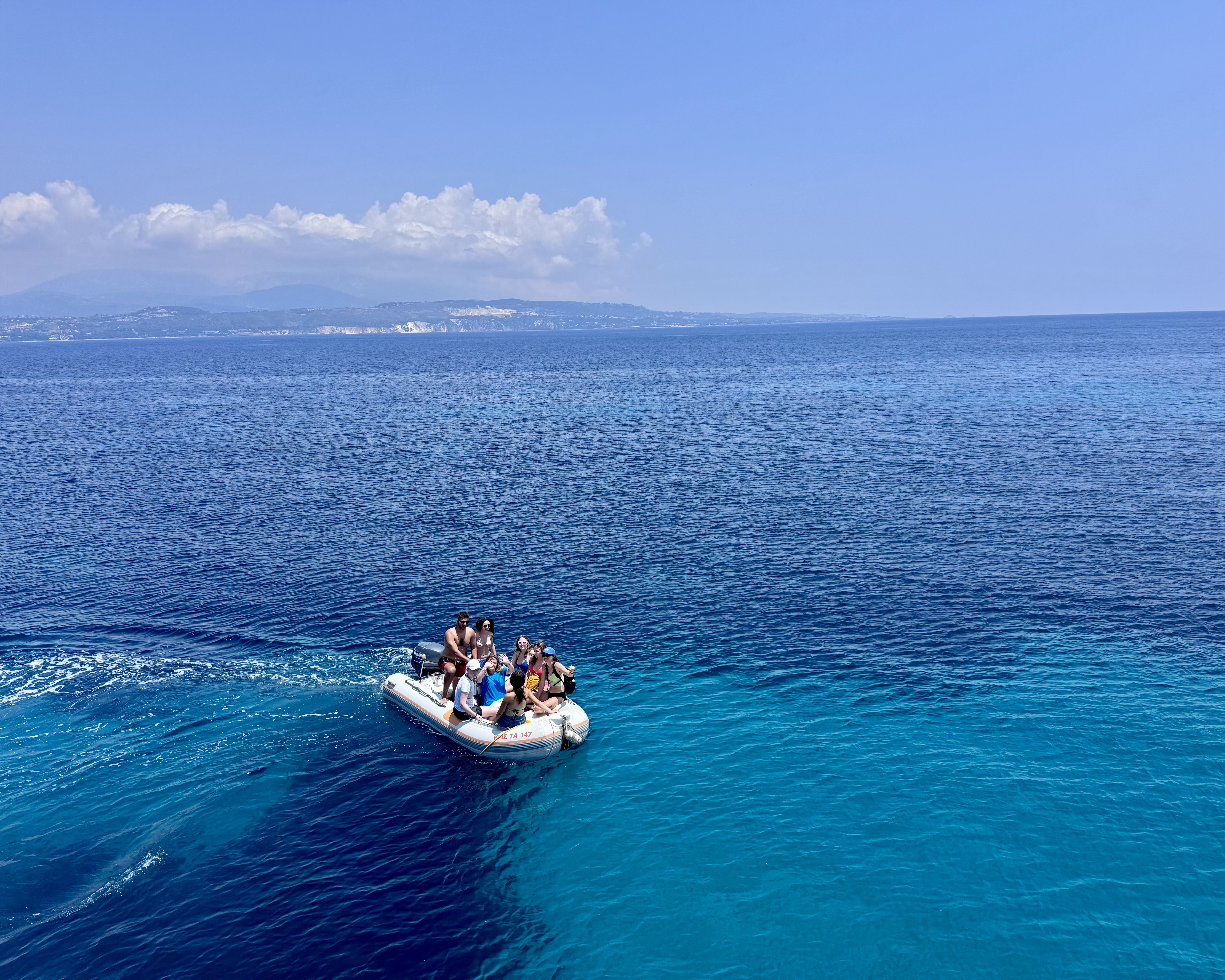 High school students riding a small boat across the deep-blue Ionian Sea off Kefalonia, Greece