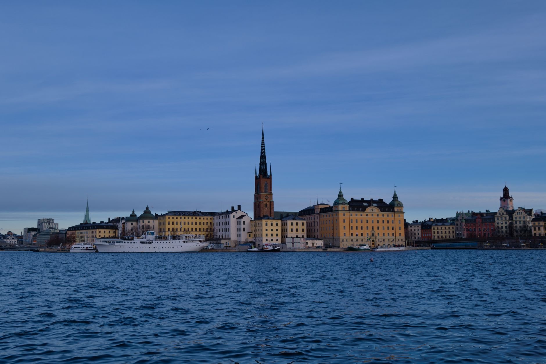The Stockholm skyline and waterways seen across open water from an island vantage point.
