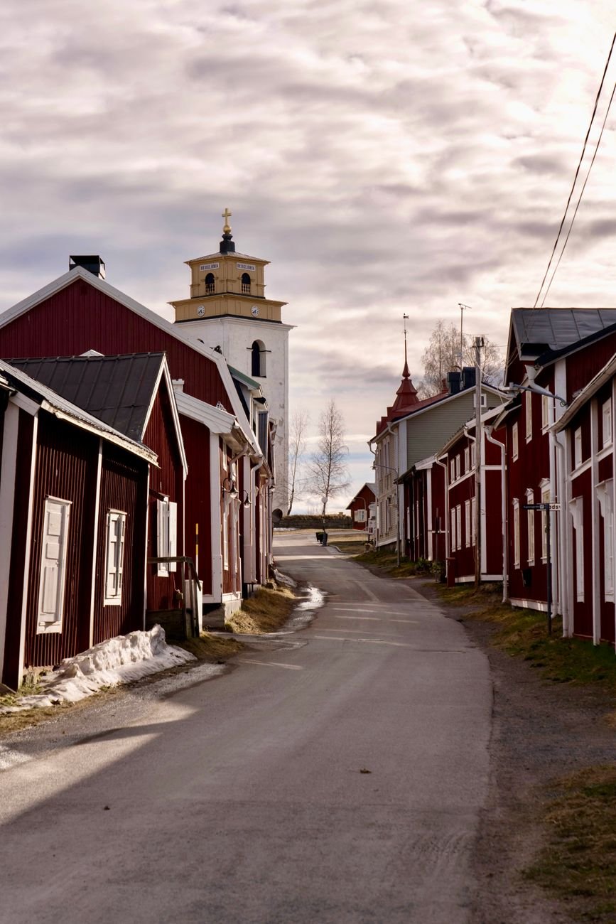 A quiet street lined with wooden buildings in a small northern Swedish town.