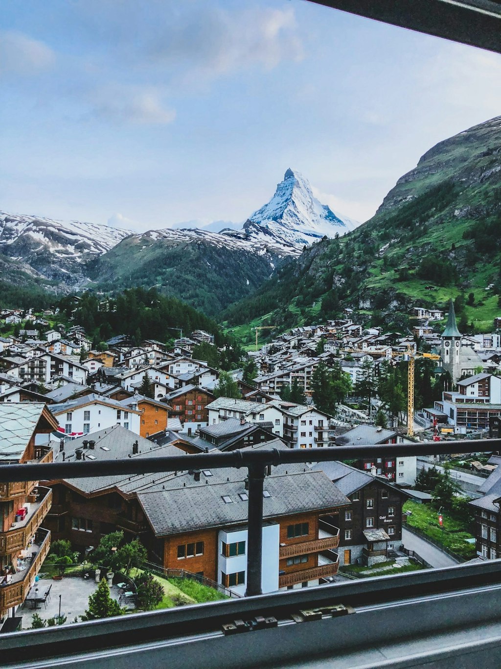 fun facts about Switzerland Photo of Zermatt, town in Switzerland with many houses and mountains in the background.