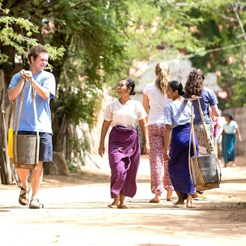Student walking with locals in a village in Thailand during a cultural immersion trip for teens