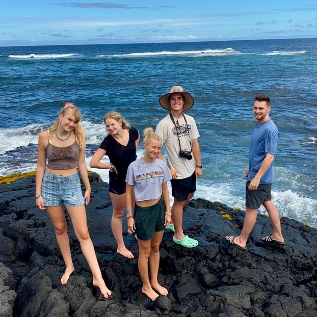 on a travel with teens is five rustic pathways students standing on the rock by the sea