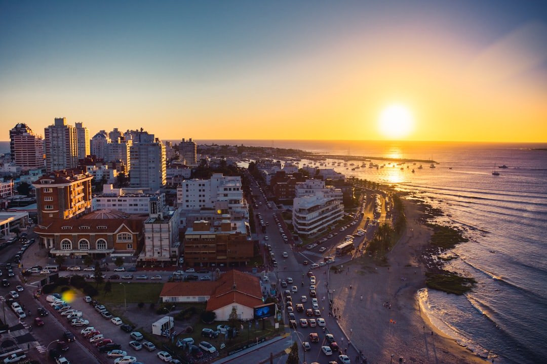 The sun setting over Punta del Este, low buildings along the shoreline and the Atlantic beyond.