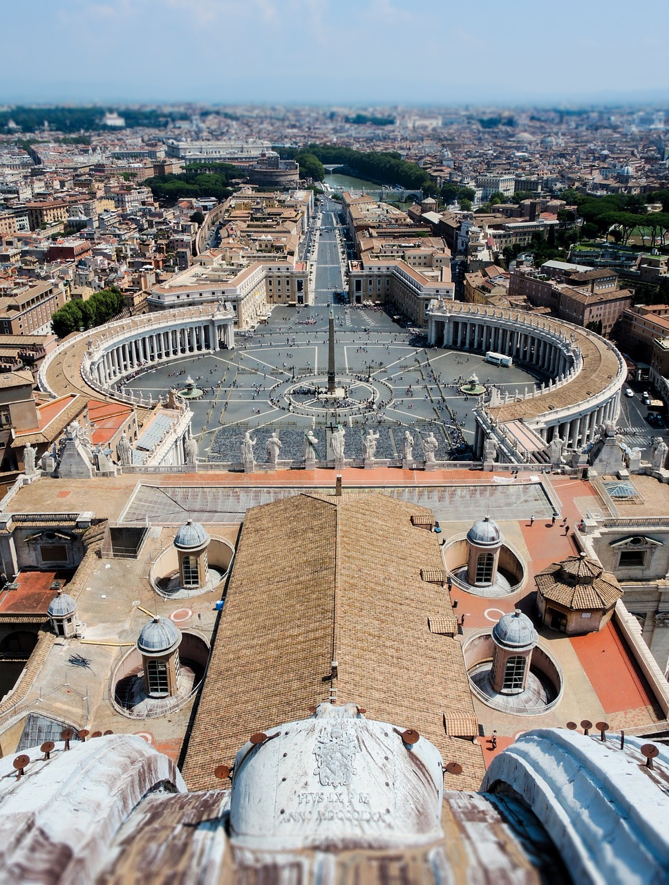 Aerial view of St. Peter's Square and its colonnade overlooking Rome's rooftops