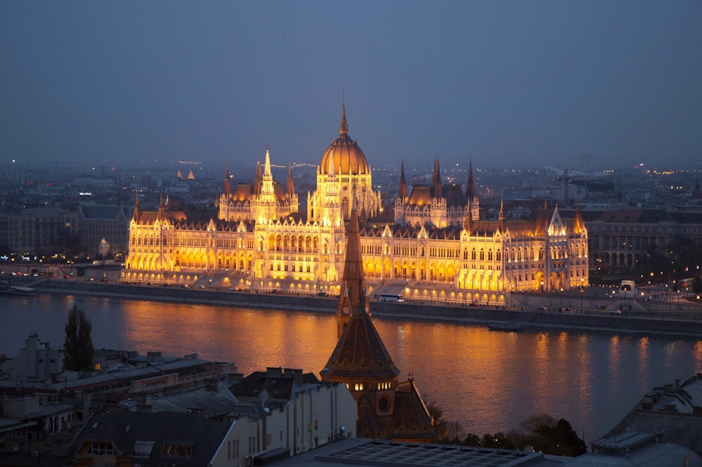 Fun facts about Hungary: A view of Budapest's Parliament Building lit up at night, showcasing its stunning architecture.