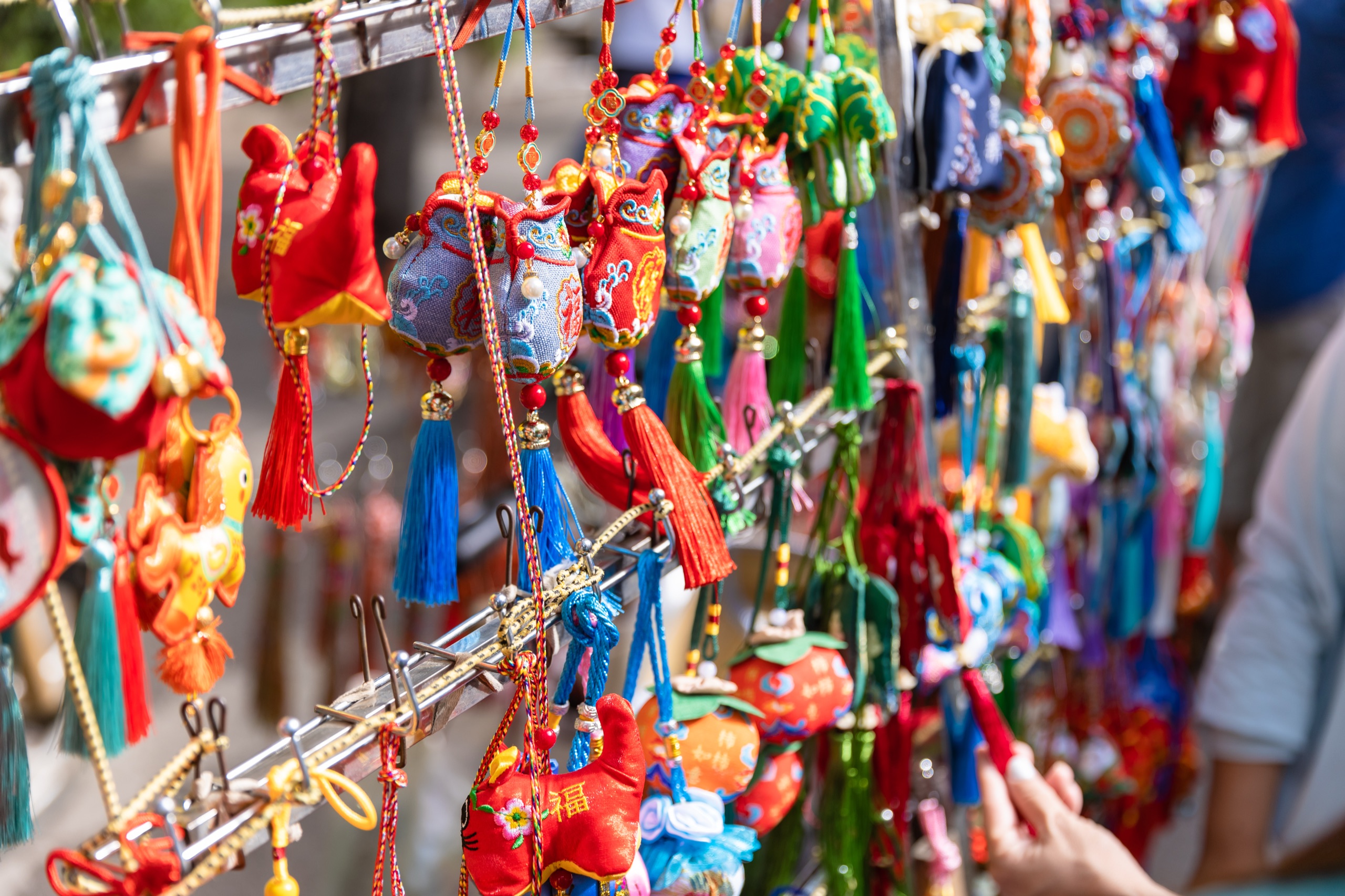 Brightly coloured embroidered souvenirs hanging at a market stall in the Muslim Quarter of Xi'an, China