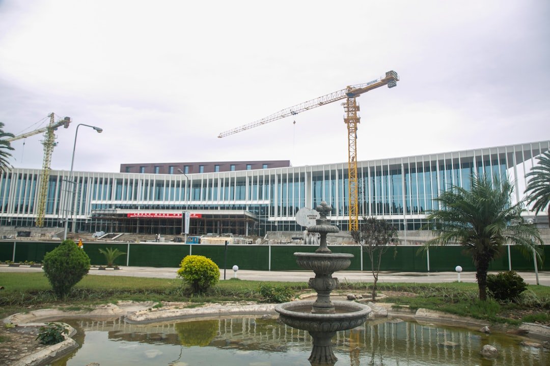 A high-rise under construction in Lusaka, a crane on its roof against an open sky.
