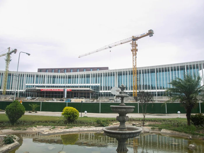 A high-rise under construction in Lusaka, a crane on its roof against an open sky.